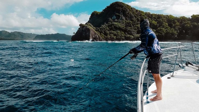 Angler casting to a reef edge below an island headland in Vanuatu